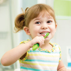 little girl is brushing her teeth