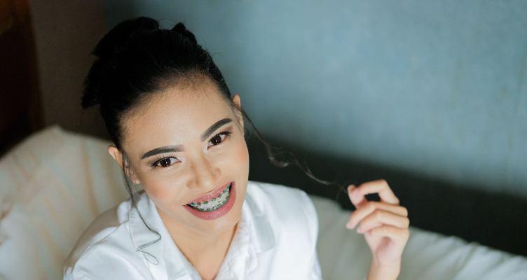 girl smiling with braces twirling a hair strand