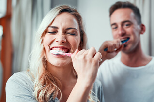 couple brushing their new dental implants