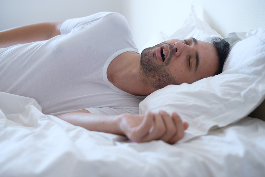 Brunette man snores with obstructive sleep apnea
