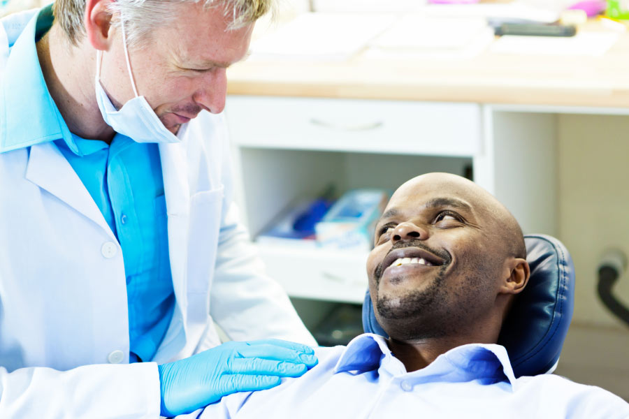 man in the dentist chairs talks to the dentist about gum health